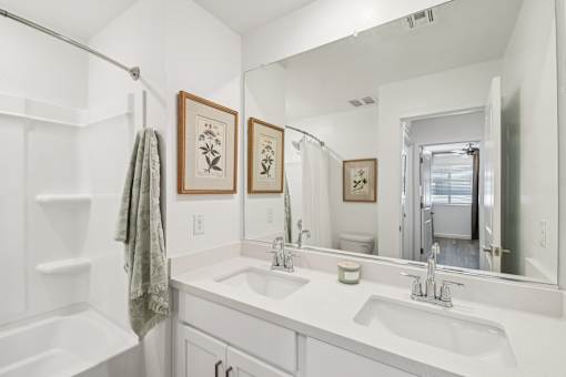 A bathroom with a white tub, sink, and towel.