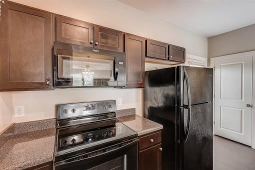 a kitchen with brown cabinets and black appliances