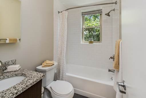 A white bathroom with a toilet, sink, and bathtub.