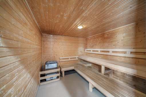 A wooden sauna room with benches and a table.