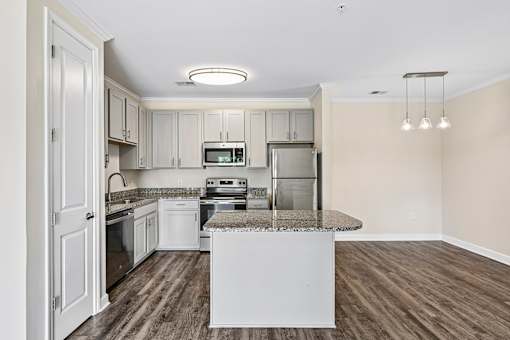 Upgraded Hawks Landing kitchen featuring stainless-steel appliances, quartz counters, and a central island