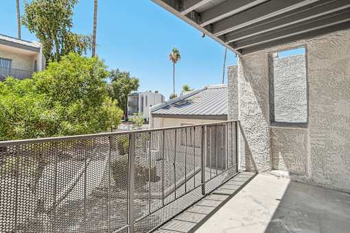 A balcony with a metal railing and a concrete wall.