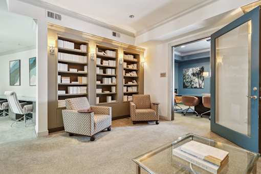 A room with a glass table and a bookshelf.
