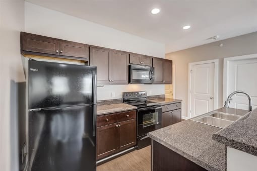 a kitchen with black appliances and granite countertops