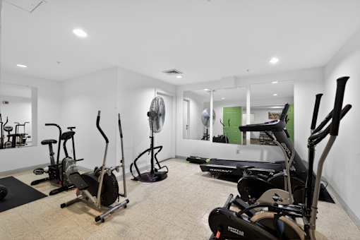 A room with a treadmill, elliptical trainer and other exercise equipment.