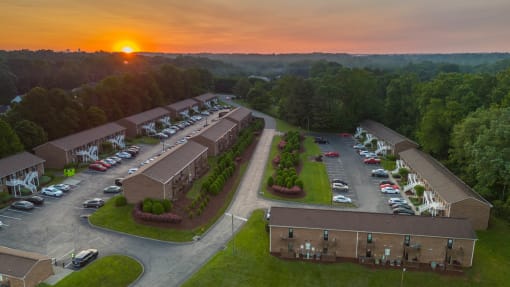 an aerial view of a parking lot and buildings at sunset