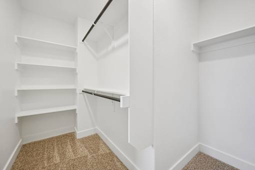A white shelving unit in a room with a carpeted floor.