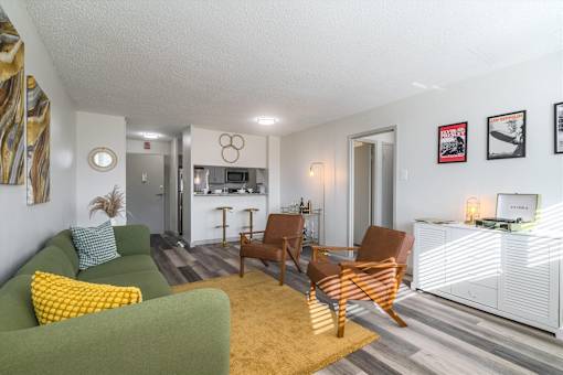 Living room at Idlewild 45 Apartments in Memphis TN featuring modern furnishings, large windows, and wood-style flooring