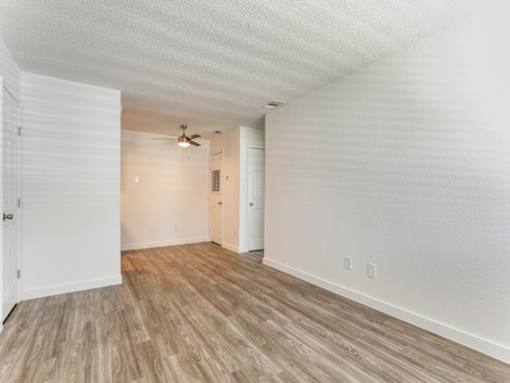 a bedroom with hardwood floors and white walls
