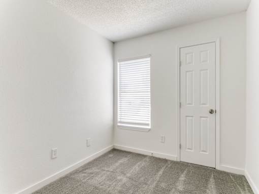 an empty room with a door and a window