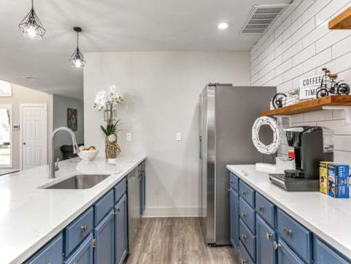 a kitchen with white countertops and blue cabinets