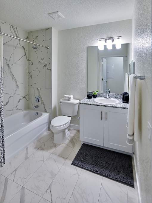 Elegant bathroom at Gateway Luxury Apartments featuring a luxury tub/shower combo with polished surfaces and sophisticated design.