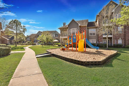 an empty playground in the middle of an apartment complex