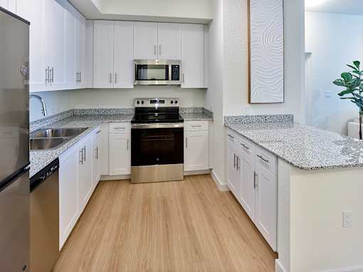 Modern kitchen design with sleek stainless-steel finishes and premium granite surfaces at Gateway Luxury Apartments.