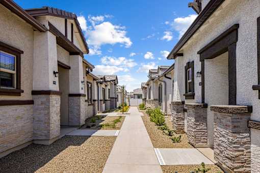 A row of houses with a sidewalk in between.