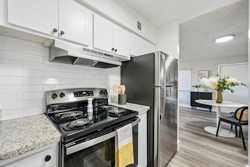 A modern kitchen with a black stove top oven and a black refrigerator.