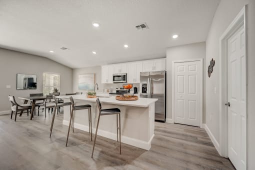 Houses in Lady Lake for Rent – The Groves at Lake Ella - a luxury kitchen with a island and a dining table with chairs