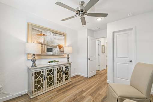 A room with a ceiling fan and a chair.
