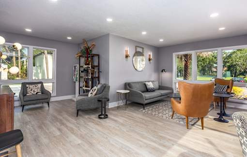 A living room with grey couches and wooden floors.