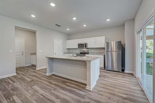 a kitchen with a large island and stainless steel appliances