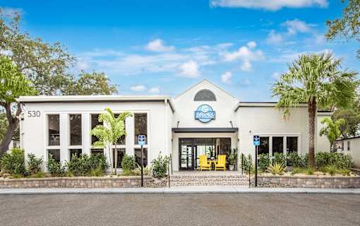 A white building with a blue sign that reads "Pet Friendly" is surrounded by greenery.
