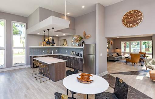 A modern kitchen with a large island and a dining table set for two.