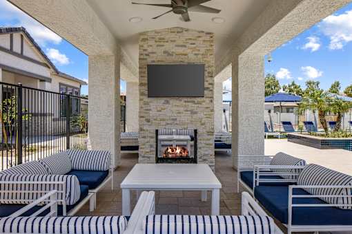 A patio with a fireplace and a television mounted on the wall.