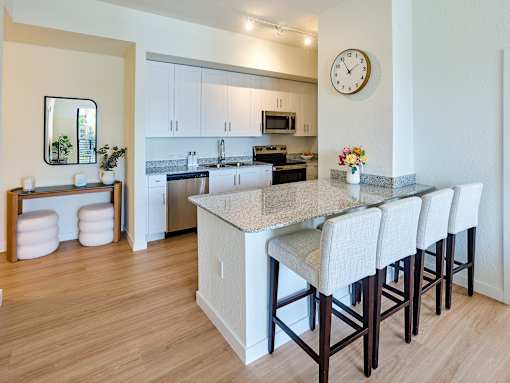 Stylish apartment kitchen at Gateway in Pompano Beach, showcasing a functional island, granite countertops, and high-end appliances.