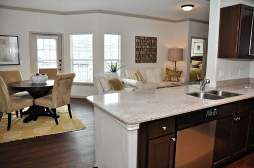 living room with wood floor and windows and kitchen with wood cabinets