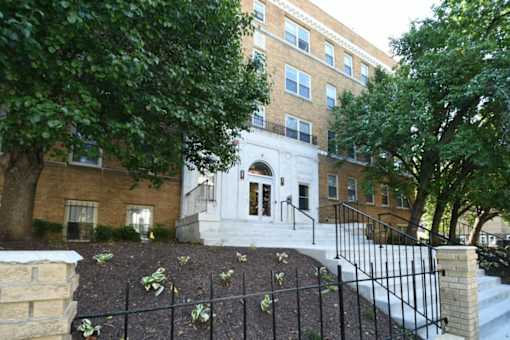 A building with a white entrance and a black fence.