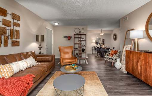 A living room with a brown leather couch and a grey coffee table.