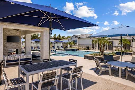 A patio with a table and chairs under a blue umbrella.