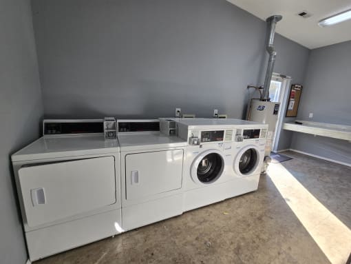 a laundry room with two washes and two dryers in it