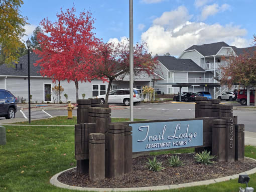 a sign for the trail college apartments in front of a parking lot