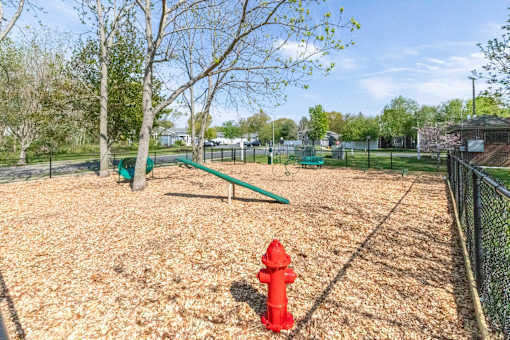 A red fire hydrant sits on a playground.