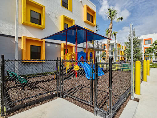 Playground area at Gateway Luxury Apartments in Pompano Beach, featuring modern play structures and a landscaped setting.