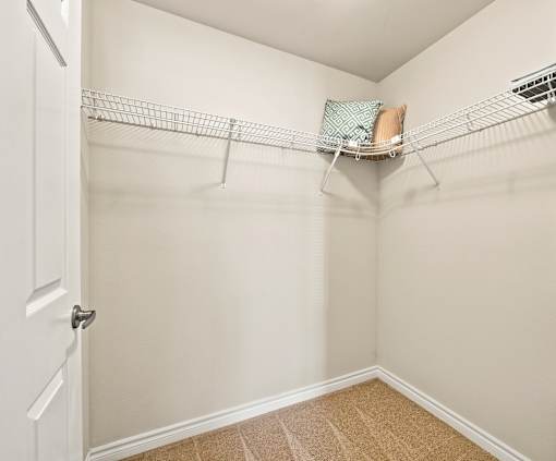 A white door is open to a room with a shelf and a pillow on it.