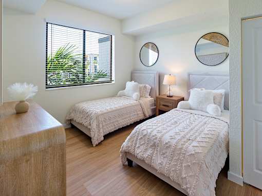 Sunlit bedroom at Gateway Luxury Apartments, showcasing a generous window that fills the space with natural light and highlights the neutral, modern design.