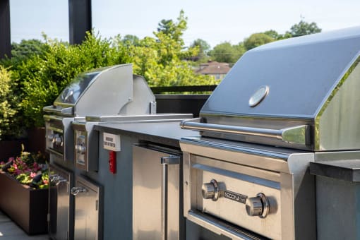 two stainless steel gas grills next to each other on a patio