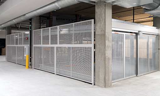 A large, empty room with a white floor and a glass partition wall.
