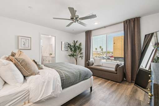 A bedroom with a large bed and a window with brown curtains.