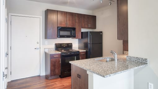 a kitchen at the enclave at woodbridge apartments in sugar land, tx