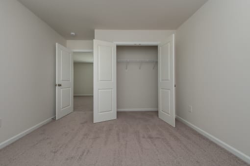 a bedroom with two closets and two doors
