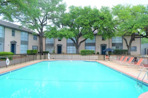 a large swimming pool in front of an apartment building