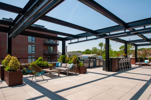 a roof top patio with furniture and a grill