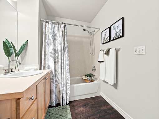 A bathroom with a white tub and a green rug.