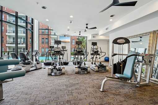 A gym with a variety of equipment including treadmills, weights, and exercise machines.
