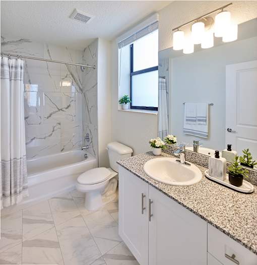 Modern bathroom at Gateway Luxury Apartments with a luxury tub and shower combo featuring sleek fixtures and elegant tilework.