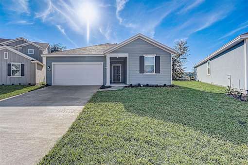 a home with a large lawn and a white garage door