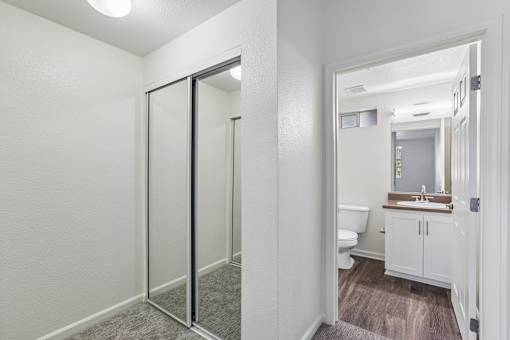A bathroom with a toilet, sink, and mirror.